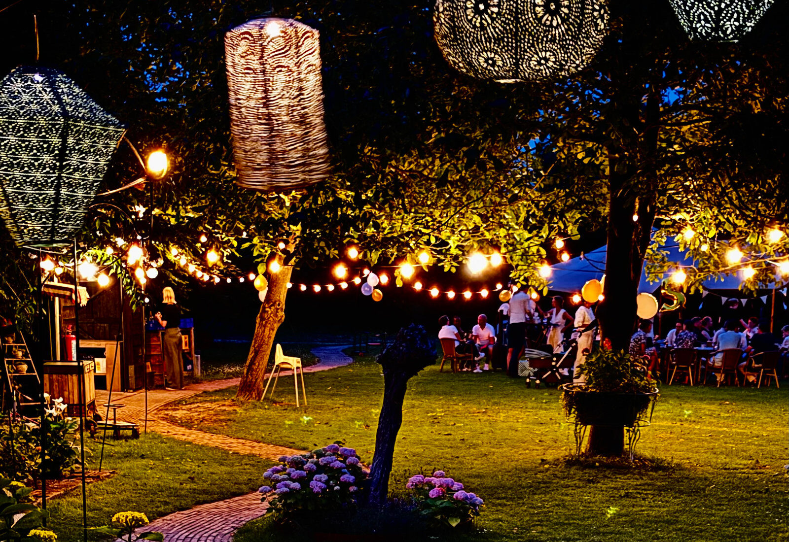 Lampionnen en lichtjes boven de tuin van Oud Vuren